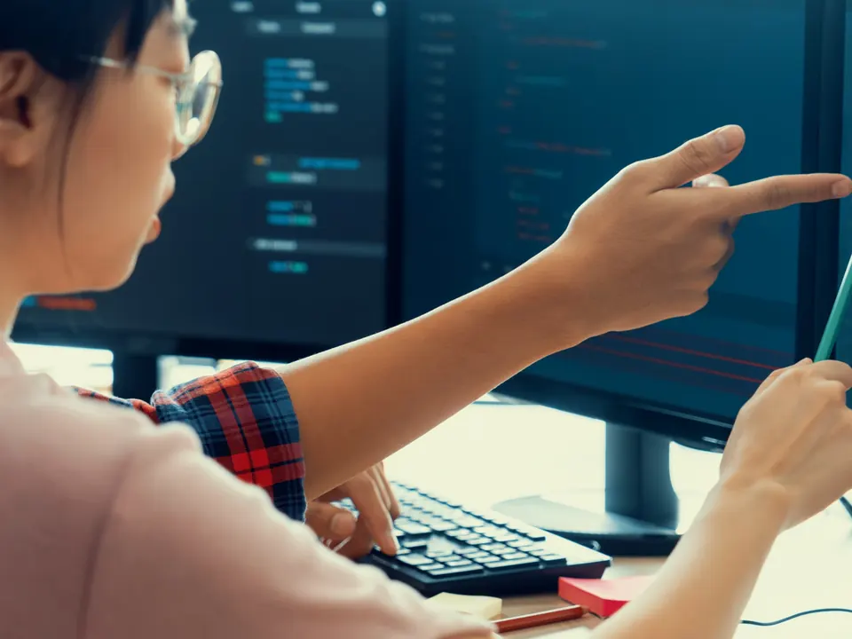 QA professional reviewing software code on a monitor